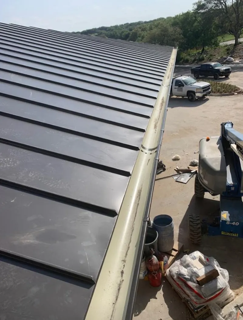 Standing seam panel and gutter detail on a metal roofing jobsite in Foxborough